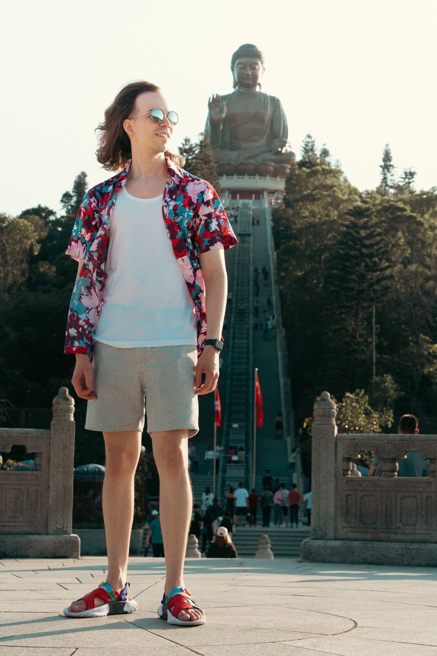 Man smiling in front of Big Buddha, Tian Tan Buddha