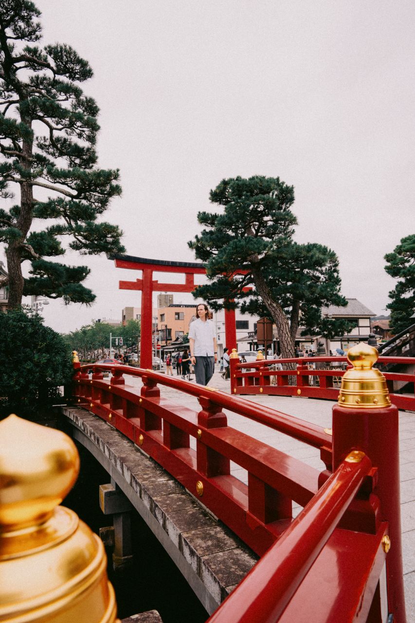 Man walking on the bridge at the entrance to Tsurugaoka Hachimangu in Kamakura.
