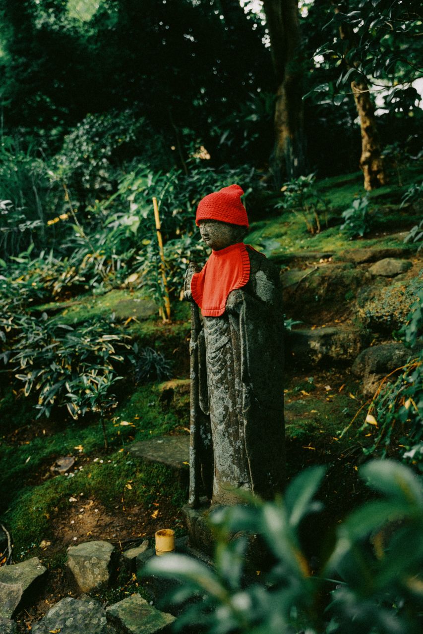 Monk statue with a red knitted hat at Hokoku-ji Temple in Kamakura, Japan.