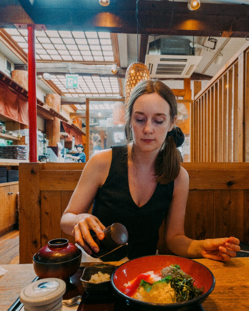 Woman eating whitebait sashimi at a restaurant on Komachi street, Kamakura.