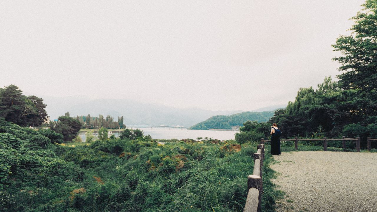 Landscape view of Kawaguchiko Lake with a woman dressed in black.