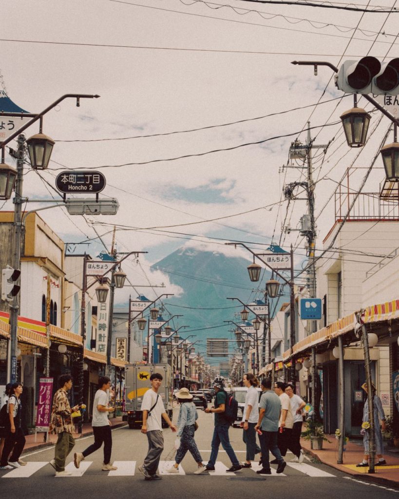 People crossing Yamanashi Street with a view of Mount Fuji.