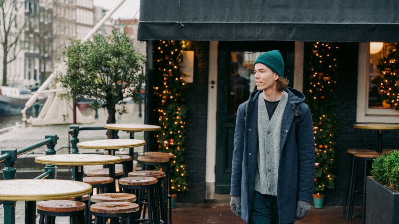 A man beside a canal with Christmas decorations in Amsterdam.
