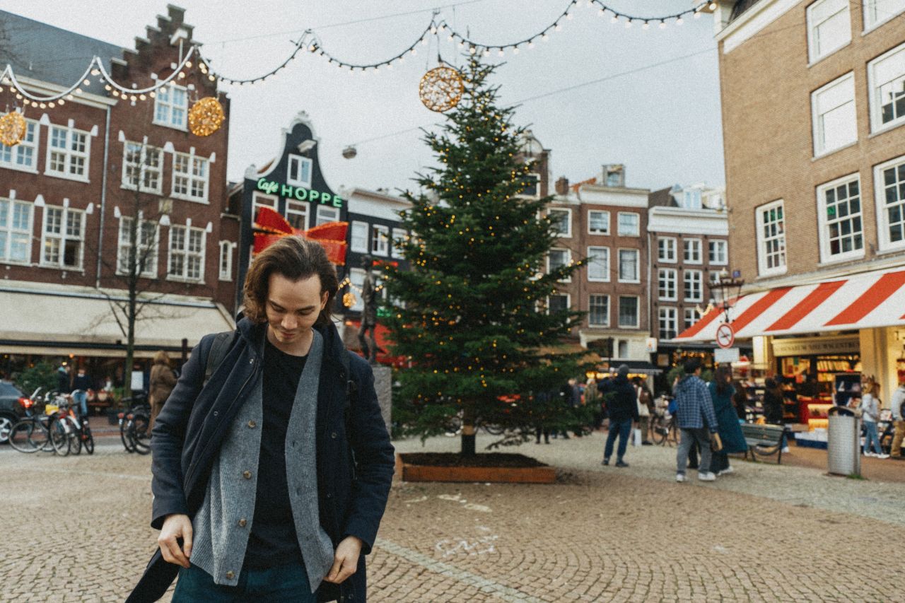 A man with a Christmas tree in the background at Lieverdje.