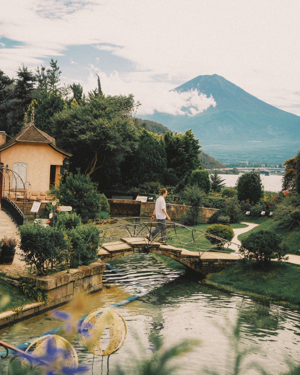 Man crossing a scenic bridge at Kawaguchiko Music Museum.
