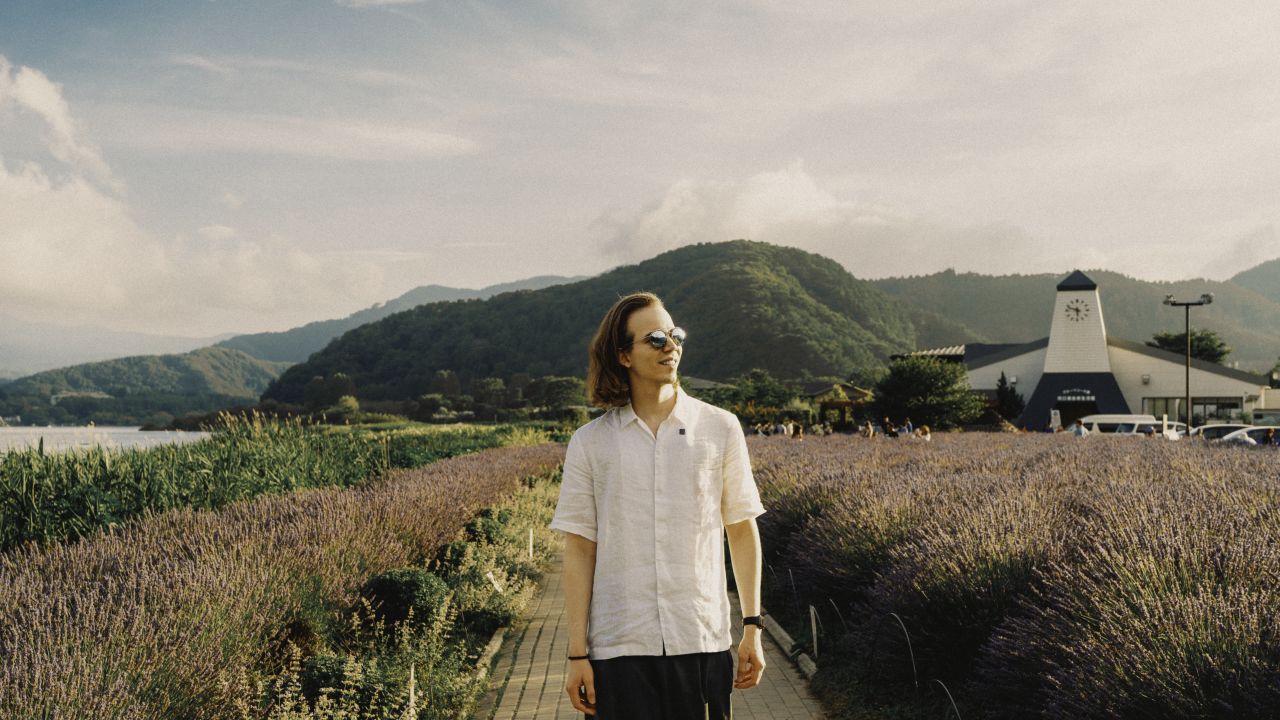 Man smiling in Oishi Park, Kawaguchiko, on a sunny day.