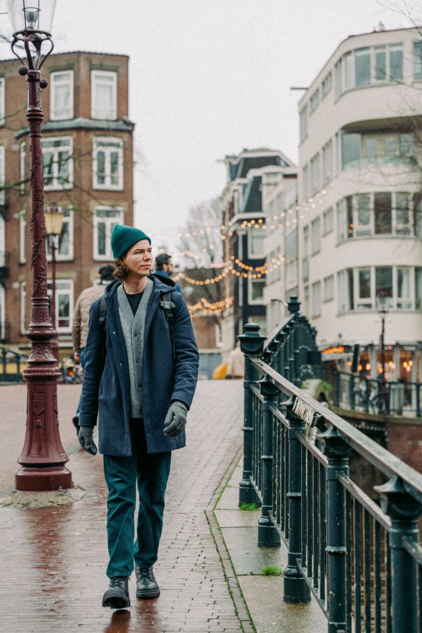A man walking in Amsterdam with Christmas decorations.