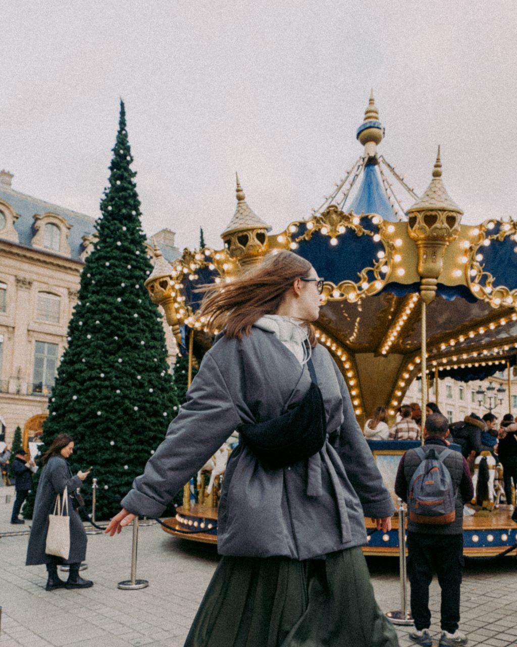 A woman with Christmas decorations at Place Vendôme.